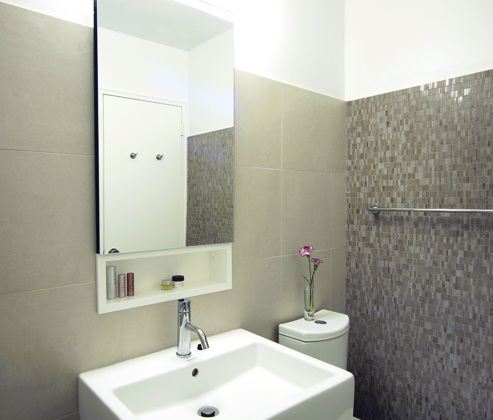 Foto di una stanza da bagno moderna con piastrelle beige e lavabo sospeso