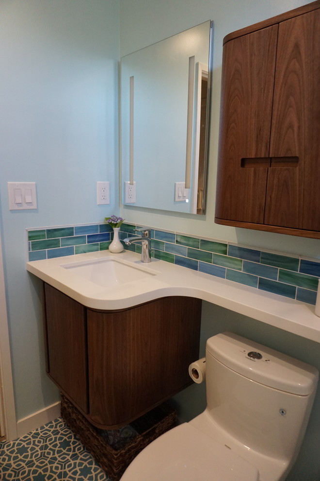 Стильный дизайн: маленькая ванная комната в стиле неоклассика (современная классика) с фасадами островного типа, темными деревянными фасадами, угловой ванной, душем в нише, унитазом-моноблоком, разноцветной плиткой, керамогранитной плиткой, синими стенами, полом из керамической плитки, врезной раковиной, столешницей из искусственного кварца, синим полом, душем с раздвижными дверями и белой столешницей для на участке и в саду - последний тренд