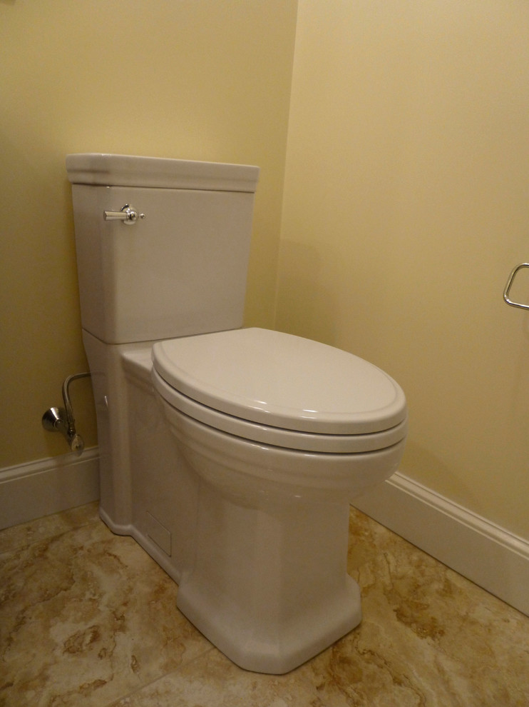 Cette image montre un petit WC et toilettes traditionnel en bois foncé avec un lavabo intégré, un placard en trompe-l'oeil, WC à poser, un carrelage beige, des carreaux de porcelaine, un mur beige et un sol en carrelage de porcelaine.