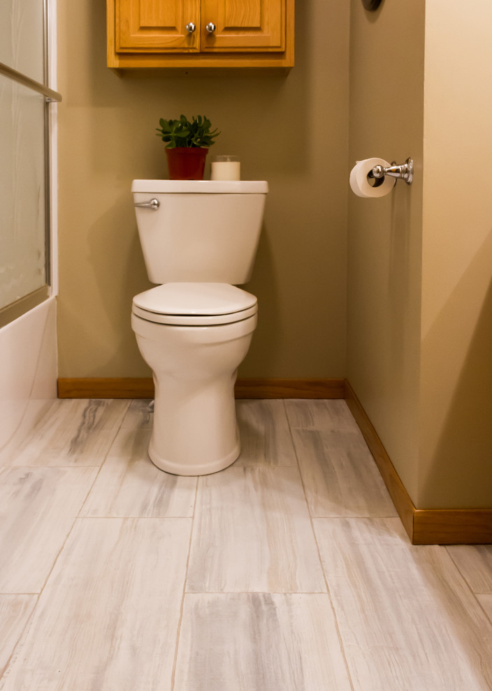 На фото: туалет среднего размера в стиле модернизм с плоскими фасадами, светлыми деревянными фасадами, раздельным унитазом, зелеными стенами, бетонным полом и разноцветным полом с