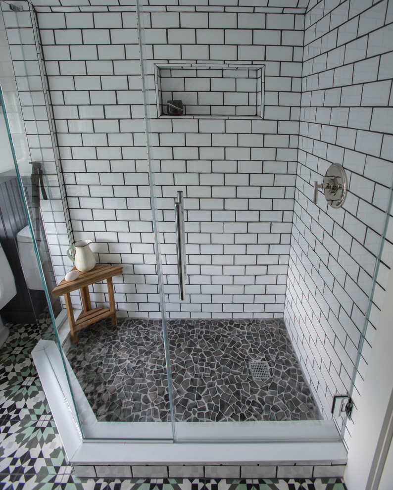 Cette image montre une petite salle de bain principale bohème avec un lavabo intégré, des portes de placard blanches, une douche d'angle, WC séparés, un carrelage blanc, un carrelage métro, un mur blanc et un sol en galet.