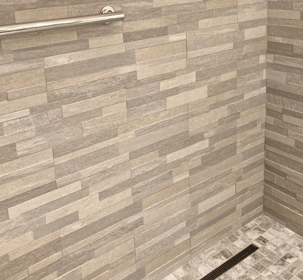 Modern inredning av ett badrum, med en bidé, flerfärgad kakel, porslinskakel, grå väggar, klinkergolv i porslin, ett undermonterad handfat, grått golv och dusch med skjutdörr