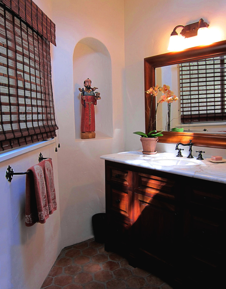 Идея дизайна: ванная комната среднего размера в средиземноморском стиле с фасадами островного типа, темными деревянными фасадами, душем над ванной, белыми стенами, полом из терракотовой плитки, душевой кабиной, врезной раковиной, мраморной столешницей, красным полом, шторкой для ванной и белой столешницей