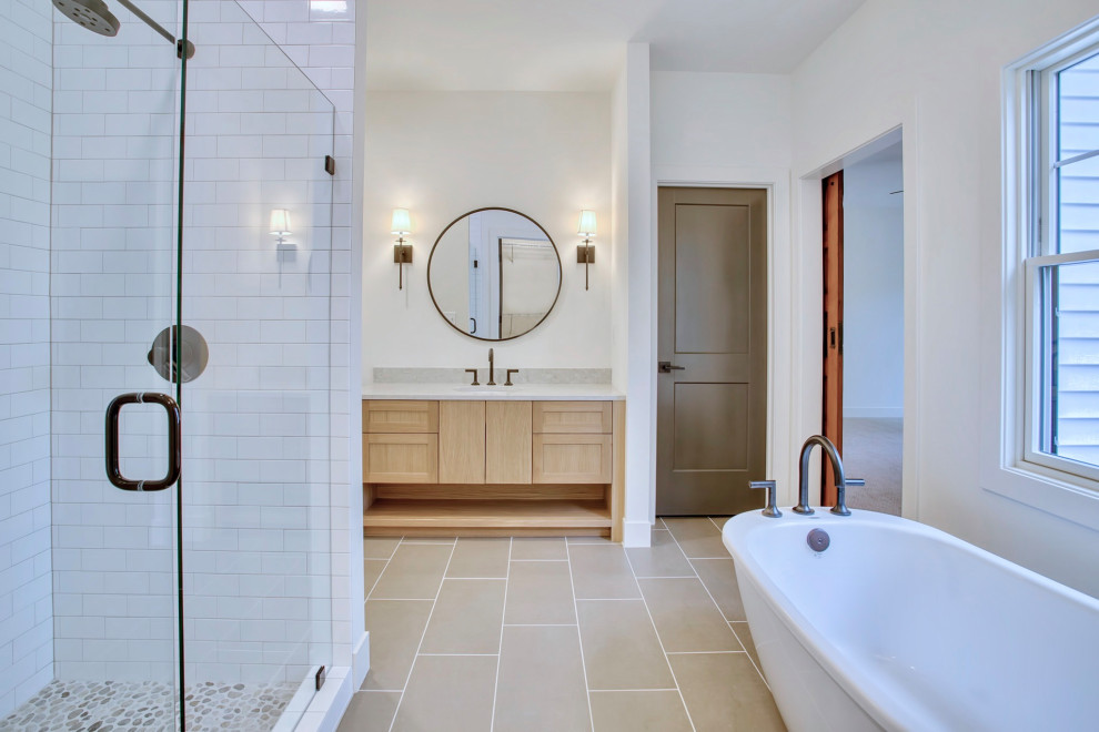 Idéer för att renovera ett mellanstort lantligt beige beige en-suite badrum, med ett fristående badkar, en dusch i en alkov, vit kakel, vita väggar, klinkergolv i keramik, ett undermonterad handfat, bänkskiva i kvarts, dusch med gångjärnsdörr, skåp i ljust trä, skåp i shakerstil, tunnelbanekakel och beiget golv