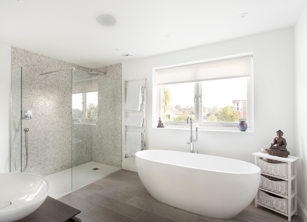 Inredning av ett modernt badrum, med ett fristående badkar, en öppen dusch, vita väggar, ett fristående handfat och med dusch som är öppen