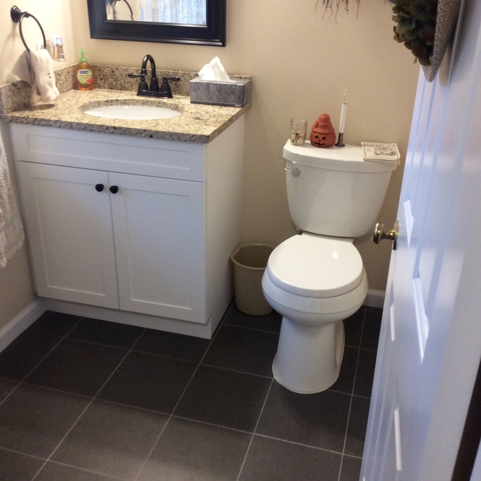 Foto di una piccola stanza da bagno con doccia chic con ante in stile shaker, ante bianche, WC a due pezzi, piastrelle nere, piastrelle di cemento, pareti beige, lavabo sottopiano, top in granito e pavimento grigio