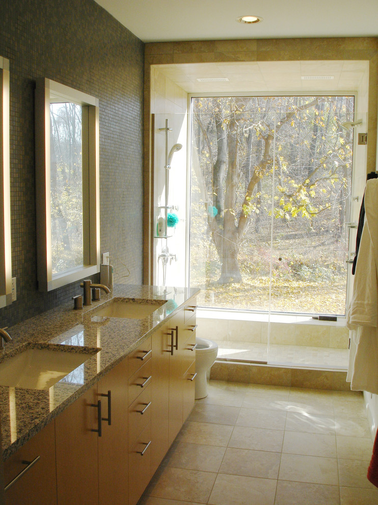 Aménagement d'une salle de bain principale moderne en bois clair de taille moyenne avec un lavabo encastré, un placard à porte plane, un plan de toilette en granite, une douche ouverte, WC à poser, un carrelage vert, un carrelage en pâte de verre, un mur beige et un sol en carrelage de céramique.
