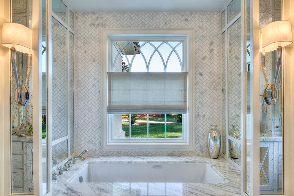 他の地域にあるラグジュアリーな中くらいなトランジショナルスタイルのおしゃれなマスターバスルーム (アンダーカウンター洗面器、白いタイル、白い壁、アンダーマウント型浴槽) の写真