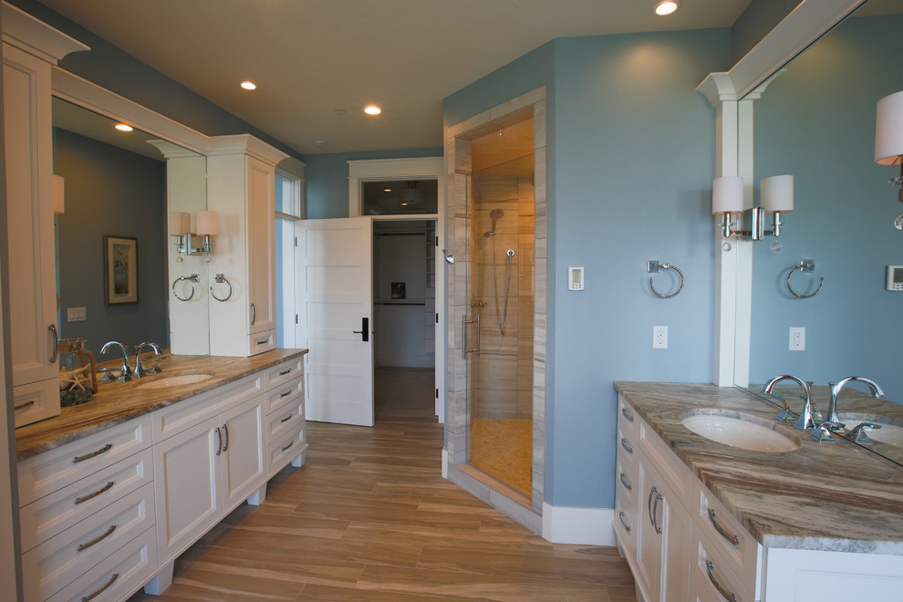 Cette image montre une grande douche en alcôve principale traditionnelle avec un lavabo encastré, un placard à porte shaker, des portes de placard blanches, une baignoire indépendante et un mur bleu.