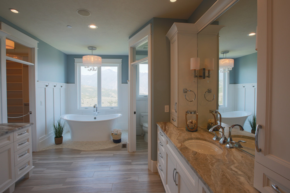 Ejemplo de cuarto de baño principal tradicional renovado grande con lavabo bajoencimera, armarios estilo shaker, puertas de armario blancas, bañera exenta, ducha empotrada y paredes azules