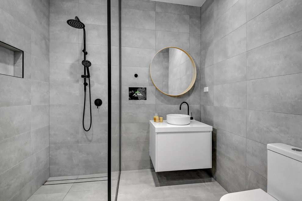 Modern inredning av ett mellanstort en-suite badrum, med släta luckor, vita skåp, ett platsbyggt badkar, våtrum, en toalettstol med separat cisternkåpa, porslinskakel, grå väggar, klinkergolv i porslin, ett konsol handfat, grått golv och med dusch som är öppen