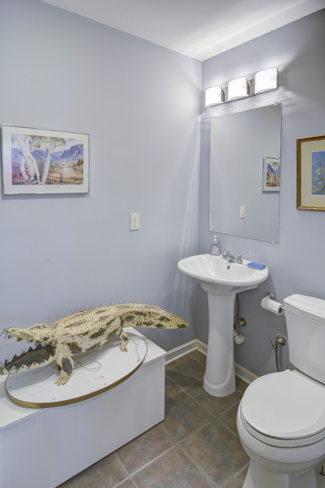 Ejemplo de cuarto de baño clásico de tamaño medio con sanitario de una pieza, baldosas y/o azulejos beige, paredes azules, suelo de baldosas de porcelana, aseo y ducha y lavabo con pedestal
