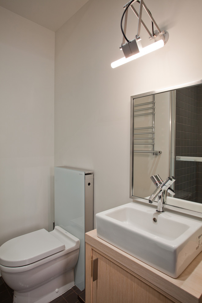 На фото: маленькая ванная комната в стиле лофт с плоскими фасадами, раздельным унитазом, белыми стенами и настольной раковиной для на участке и в саду