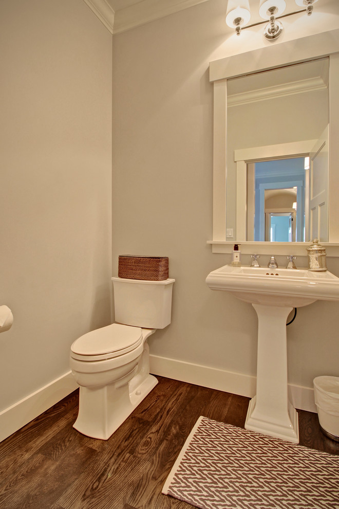Ispirazione per una piccola stanza da bagno american style con lavabo a colonna, pareti bianche e parquet scuro