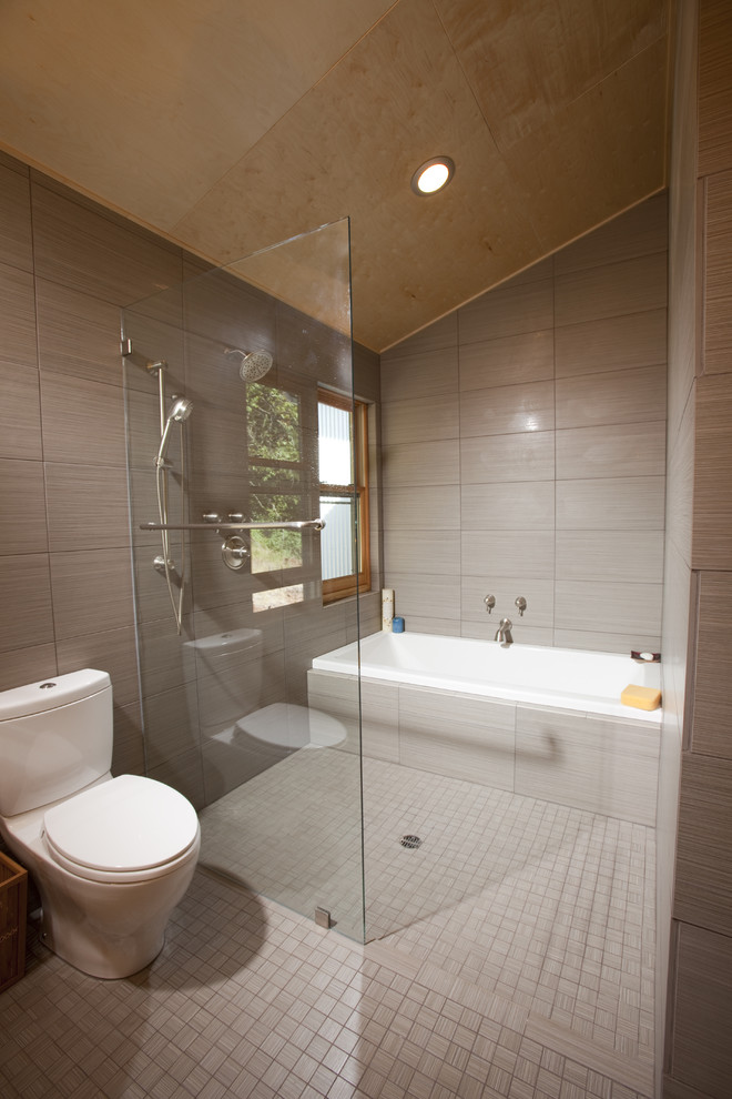 ポートランドにあるコンテンポラリースタイルのおしゃれな浴室 (アルコーブ型浴槽、一体型トイレ	、グレーのタイル、バリアフリー) の写真