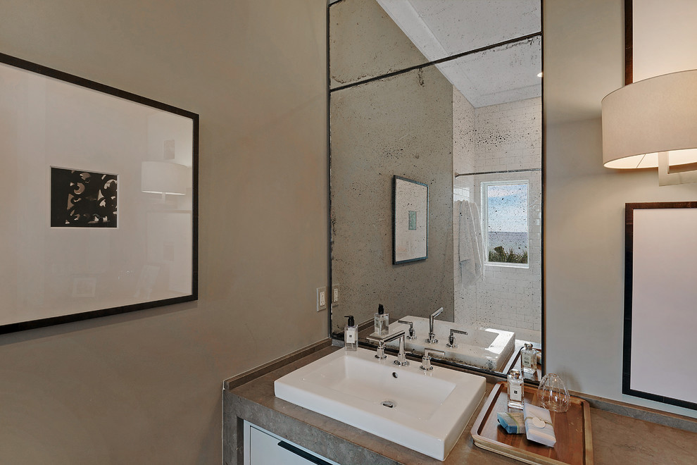 На фото: ванная комната в морском стиле с душем над ванной, серыми стенами и настольной раковиной с
