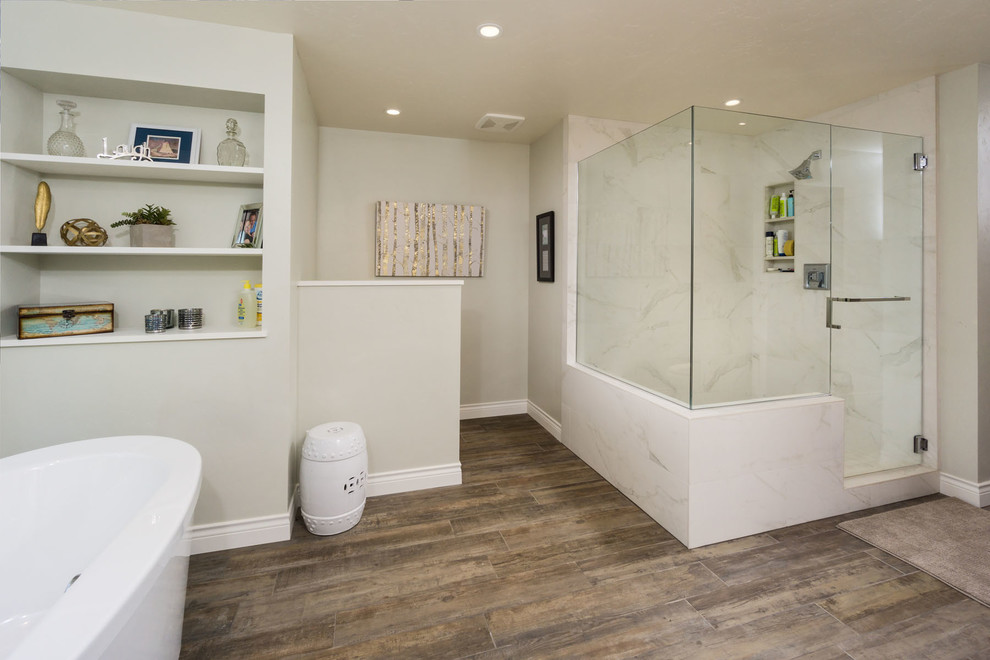 Réalisation d'une salle de bain principale champêtre avec un placard en trompe-l'oeil, des portes de placard grises, une baignoire indépendante, une douche d'angle, un mur gris, un sol en bois brun, un lavabo encastré et un plan de toilette en béton.
