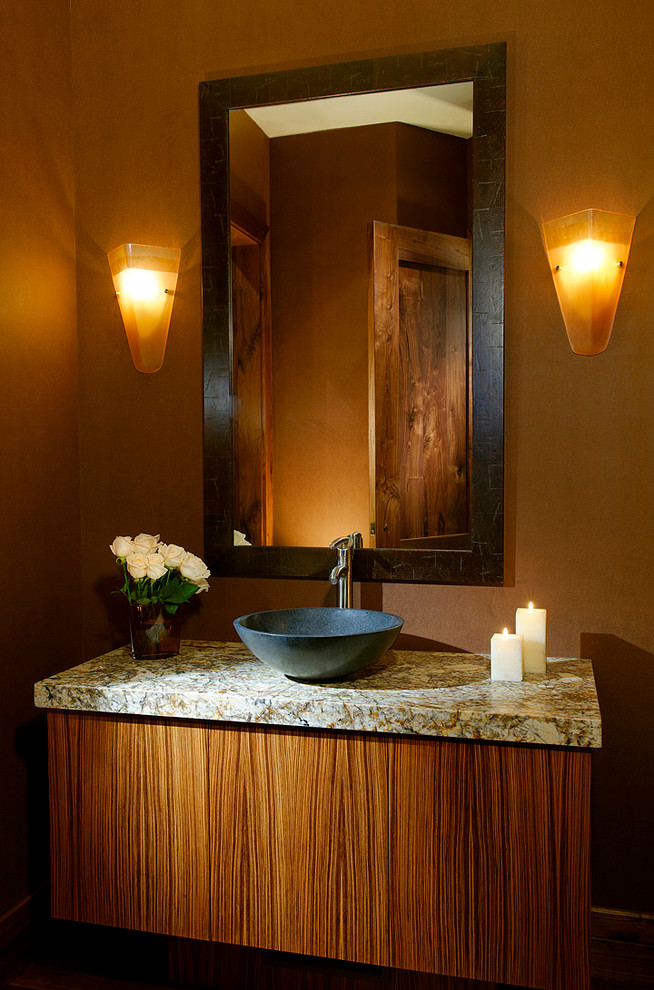 Aménagement d'une salle de bain classique en bois brun avec un placard à porte plane, un mur marron et un plan de toilette en granite.