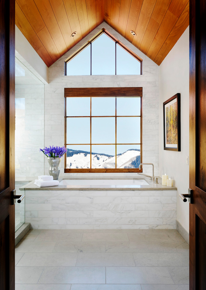 Bathroom - transitional master white tile and stone tile limestone floor bathroom idea in Denver with an undermount tub, a two-piece toilet, white walls, an undermount sink and granite countertops