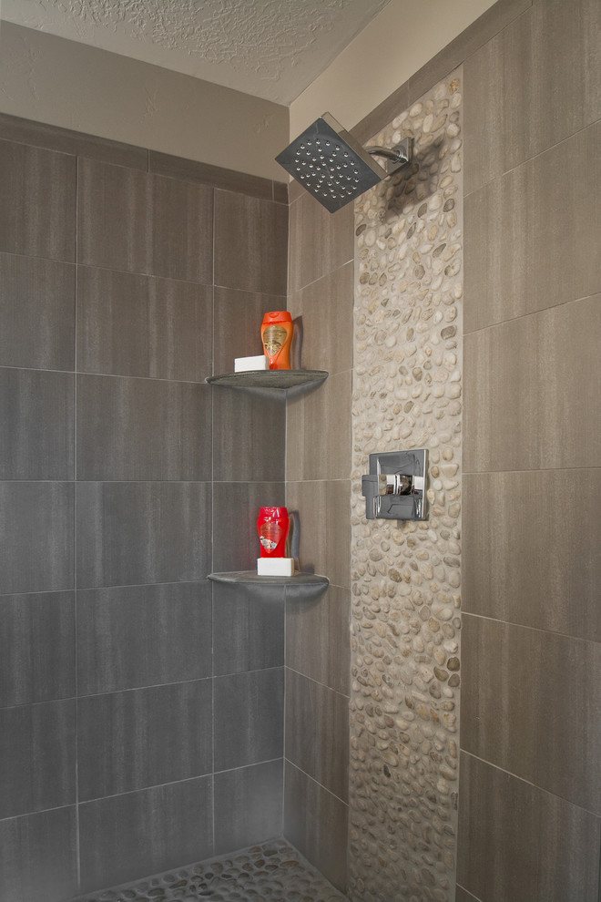Immagine di una stanza da bagno design con doccia ad angolo, piastrelle grigie, lastra di pietra e pareti beige