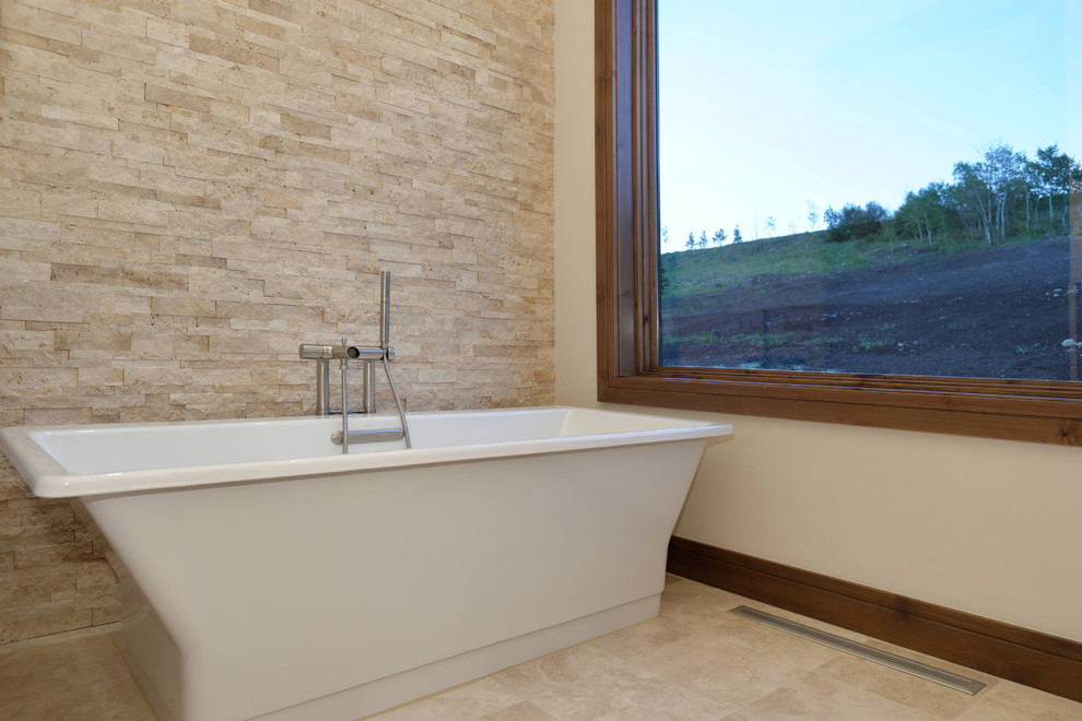Immagine di una stanza da bagno stile rurale con vasca freestanding e piastrelle beige