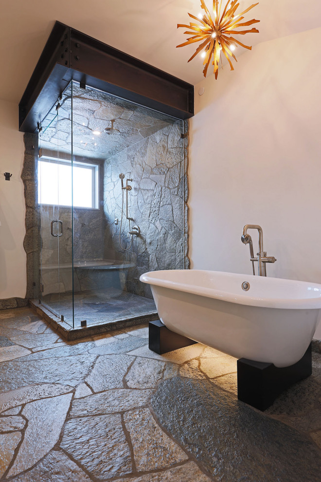 Foto på ett stort rustikt en-suite badrum, med ett fristående badkar, en hörndusch, grå kakel, stenhäll, vita väggar, grått golv och dusch med gångjärnsdörr