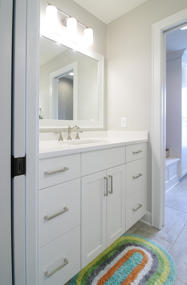 Diseño de cuarto de baño infantil clásico renovado grande con armarios estilo shaker, puertas de armario blancas, bañera empotrada, paredes grises, lavabo bajoencimera, suelo gris y encimeras blancas