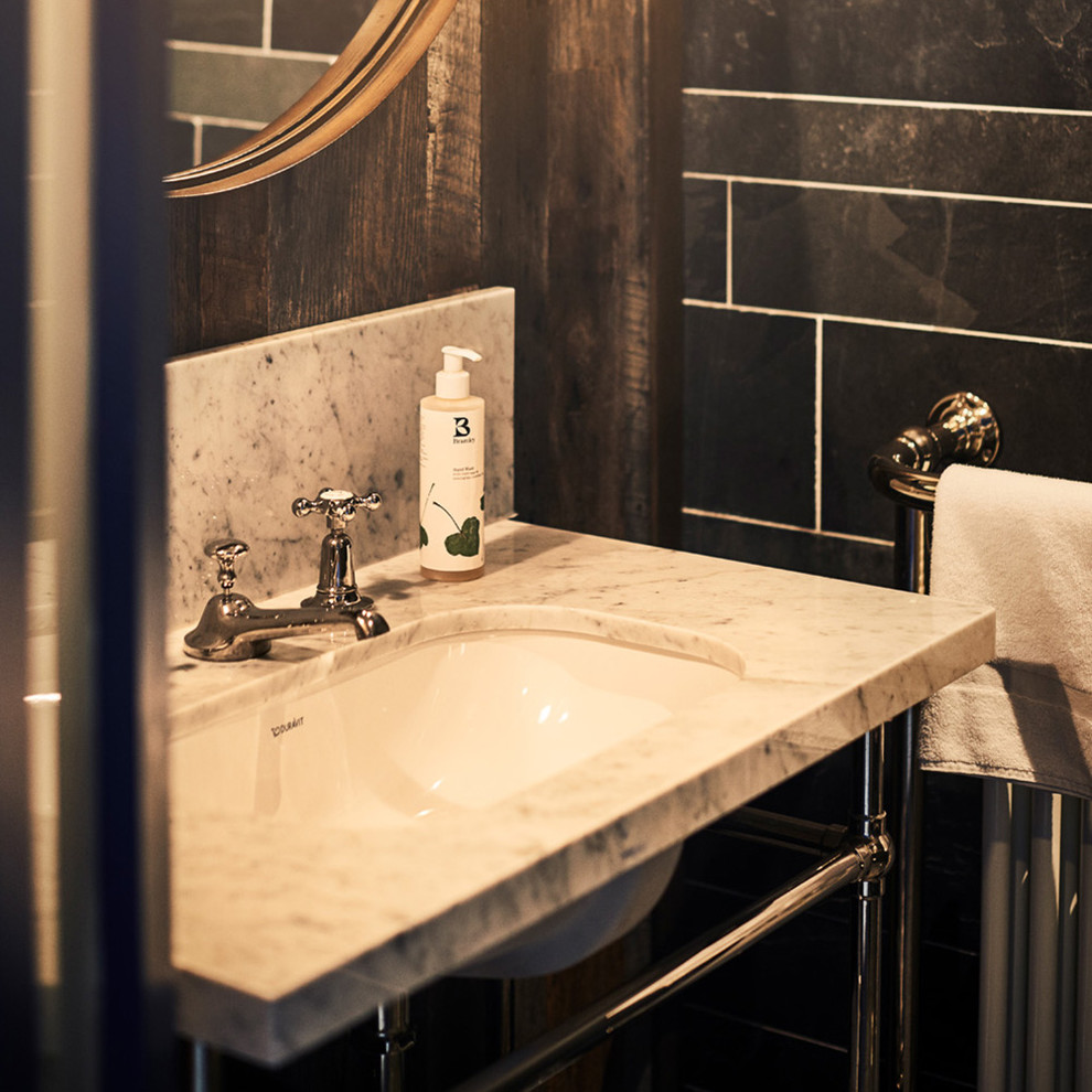 サセックスにある高級な中くらいなラスティックスタイルのおしゃれなマスターバスルーム (洗い場付きシャワー、グレーのタイル、スレートタイル、オーバーカウンターシンク、大理石の洗面台、白い洗面カウンター) の写真