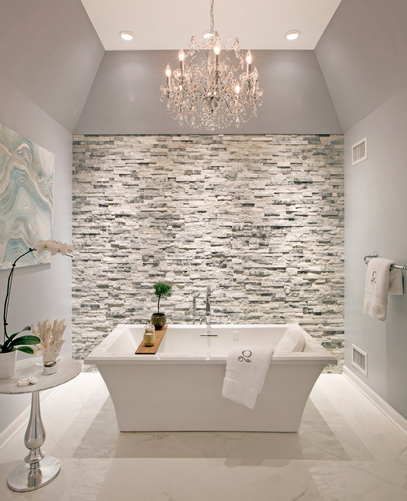 Aménagement d'une grande salle de bain principale classique avec une baignoire indépendante, un carrelage gris, un carrelage de pierre, un mur gris, un sol en marbre et un sol blanc.