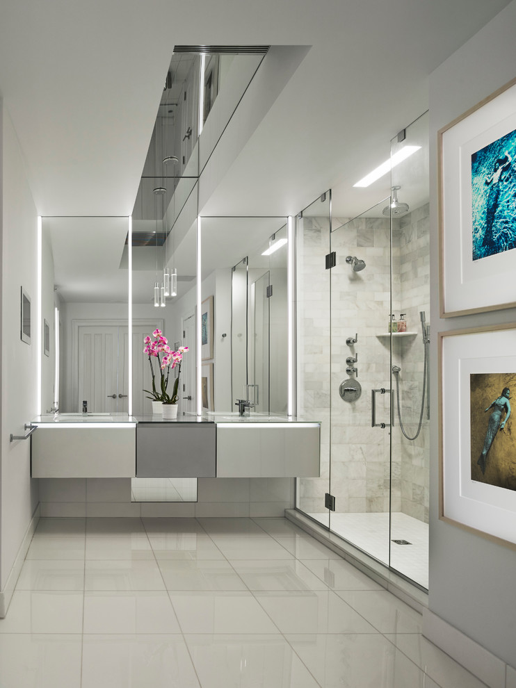 Réalisation d'une grande salle de bain principale design avec un lavabo intégré, un plan de toilette en verre, une douche double et un mur blanc.