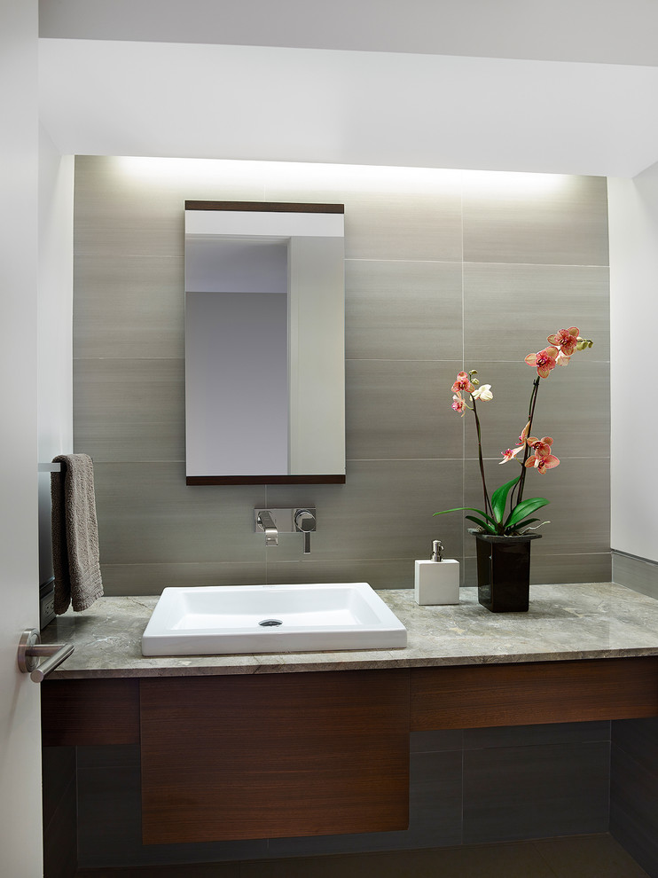 Immagine di una stanza da bagno contemporanea con lavabo da incasso, ante lisce, ante in legno scuro, piastrelle grigie, piastrelle in gres porcellanato e pavimento in gres porcellanato