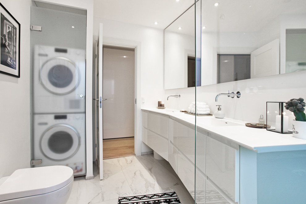 This is an example of a medium sized modern bathroom in Aarhus with white cabinets, white walls, flat-panel cabinets and a laundry area.