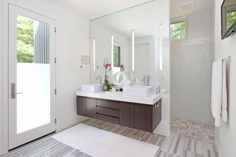 Diseño de cuarto de baño rectangular contemporáneo con lavabo sobreencimera, armarios con paneles lisos, puertas de armario de madera en tonos medios, baldosas y/o azulejos blancos, baldosas y/o azulejos de cemento y paredes blancas