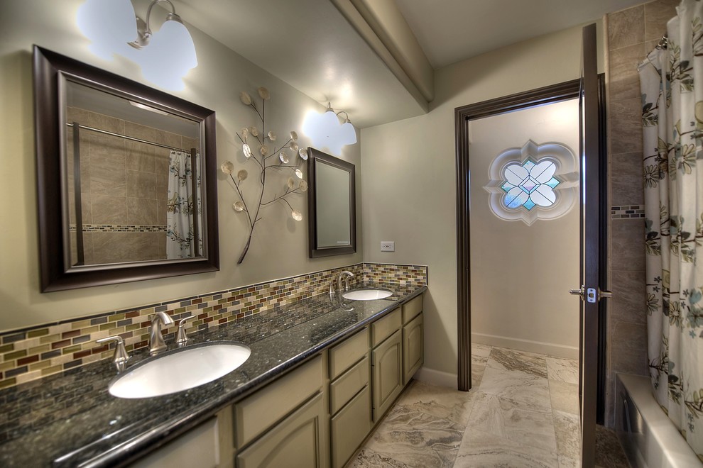 Mid-sized transitional master beige tile and stone tile travertine floor bathroom photo in Phoenix with an undermount sink, green cabinets, granite countertops, a one-piece toilet and green walls