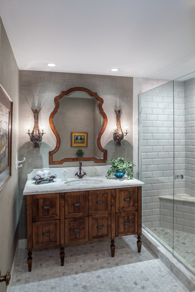 Large french country 3/4 white tile and subway tile marble floor and gray floor bathroom photo in Other with an undermount sink, furniture-like cabinets, medium tone wood cabinets, marble countertops, a one-piece toilet, beige walls and white countertops