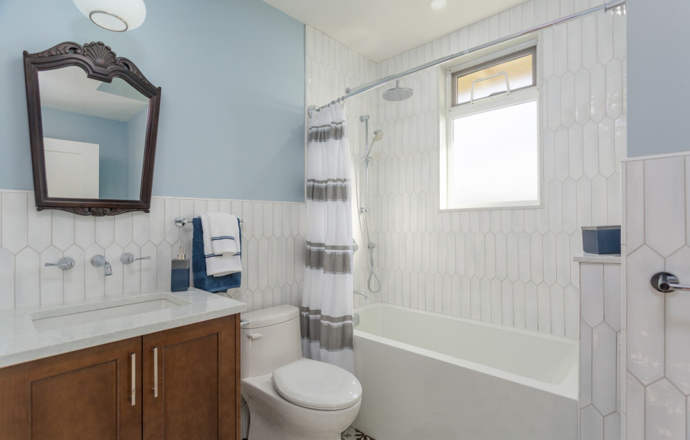 Mid-sized transitional kids' white tile and porcelain tile bathroom photo in Vancouver with a one-piece toilet, an undermount sink, quartz countertops, white countertops, shaker cabinets, medium tone wood cabinets and blue walls