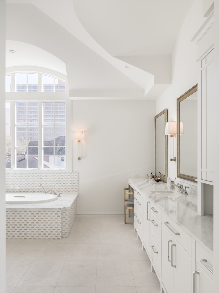 Идея дизайна: огромная главная ванная комната в современном стиле с плоскими фасадами, белыми фасадами, накладной ванной, двойным душем, керамогранитной плиткой, белыми стенами, полом из керамогранита, врезной раковиной, мраморной столешницей, бежевым полом и душем с распашными дверями