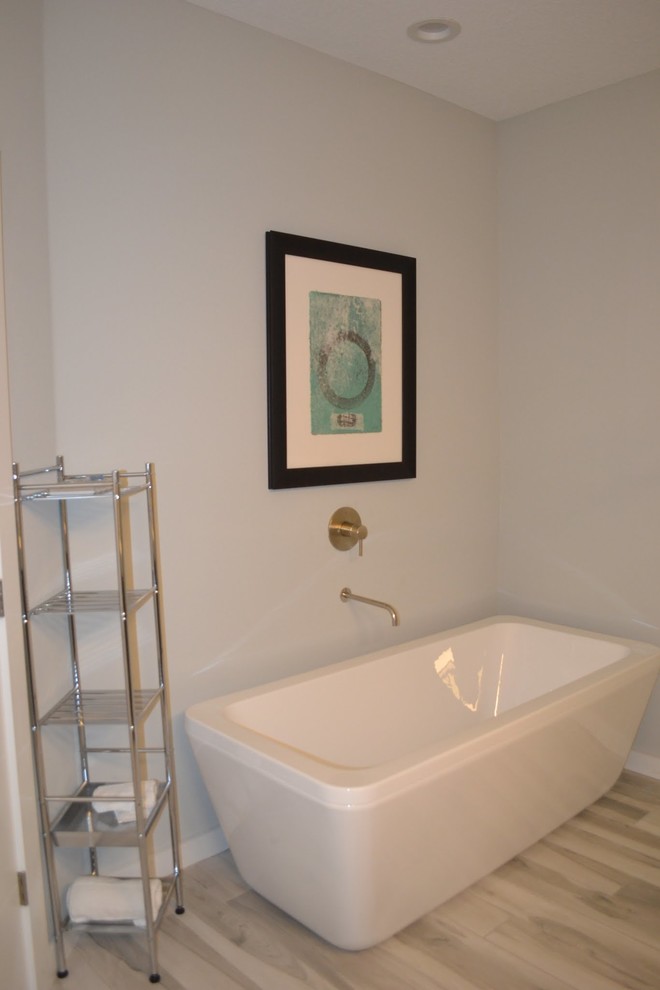 This is an example of a modern ensuite bathroom in Tampa with a freestanding bath, grey tiles, blue walls, porcelain flooring and a built-in sink.