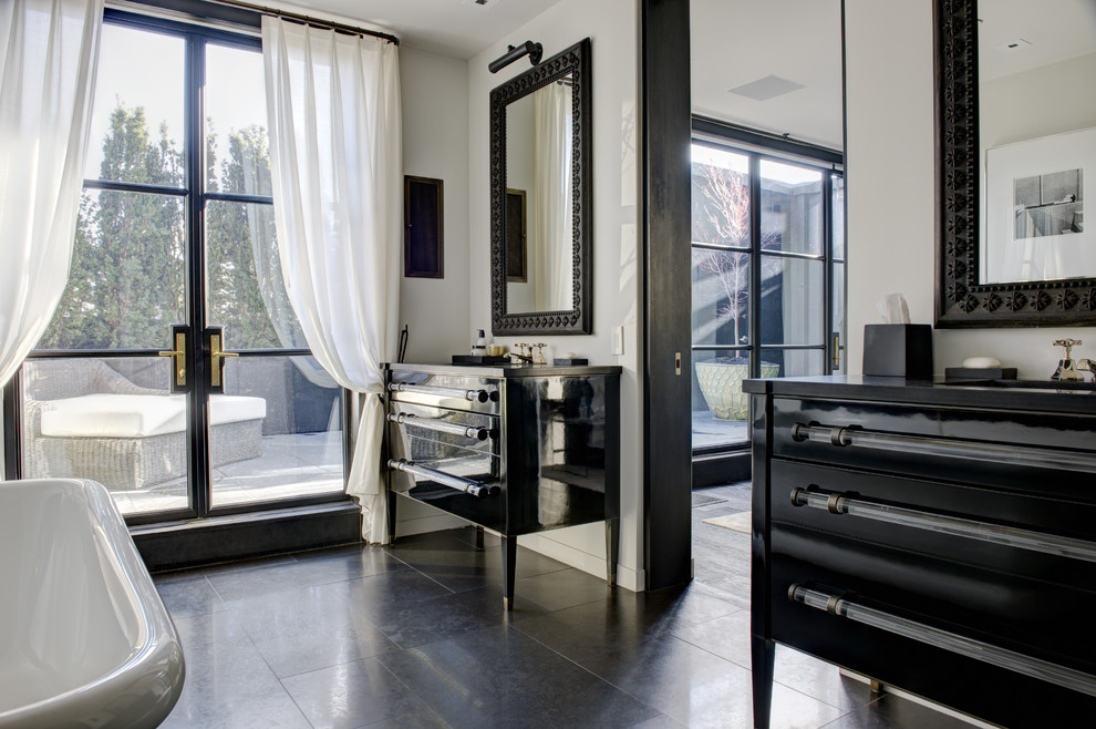 ニューヨークにあるコンテンポラリースタイルのおしゃれな浴室 (アンダーカウンター洗面器、黒いキャビネット、置き型浴槽、フラットパネル扉のキャビネット) の写真