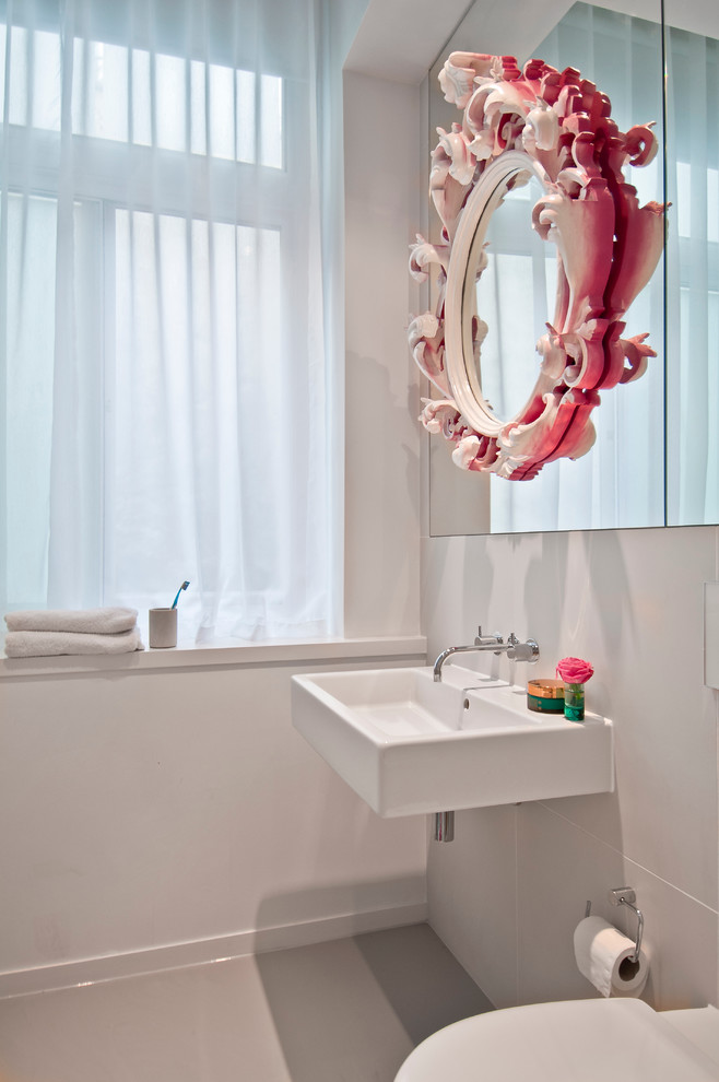 Immagine di una stanza da bagno design con lavabo sospeso e pareti bianche