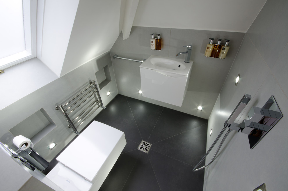 Inspiration for a small contemporary master gray tile porcelain tile doorless shower remodel in London with white cabinets, a wall-mount toilet, gray walls, a wall-mount sink and flat-panel cabinets