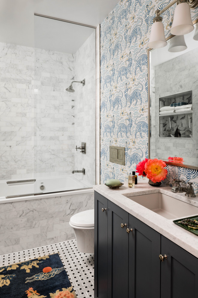 На фото: ванная комната в стиле неоклассика (современная классика) с фасадами в стиле шейкер, черными фасадами, ванной в нише, душем над ванной, синими стенами, полом из мозаичной плитки, врезной раковиной, разноцветным полом, открытым душем, белой столешницей, встроенной тумбой и обоями на стенах