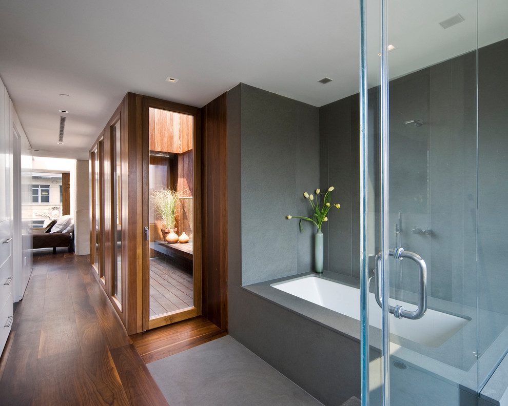Пример оригинального дизайна: ванная комната в стиле модернизм с полновстраиваемой ванной и серой плиткой