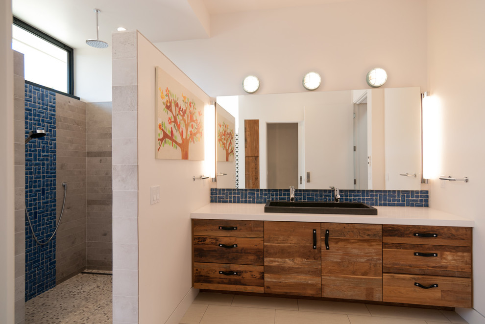 Modelo de cuarto de baño rectangular contemporáneo con lavabo sobreencimera, armarios con paneles lisos, puertas de armario de madera oscura, ducha empotrada y baldosas y/o azulejos azules