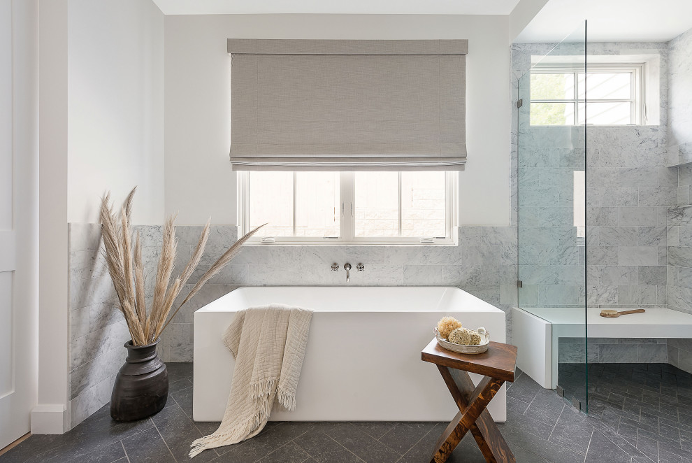 Photo of a medium sized rural bathroom in San Diego with a freestanding bath, a corner shower, grey tiles, grey walls, grey floors and a shower bench.