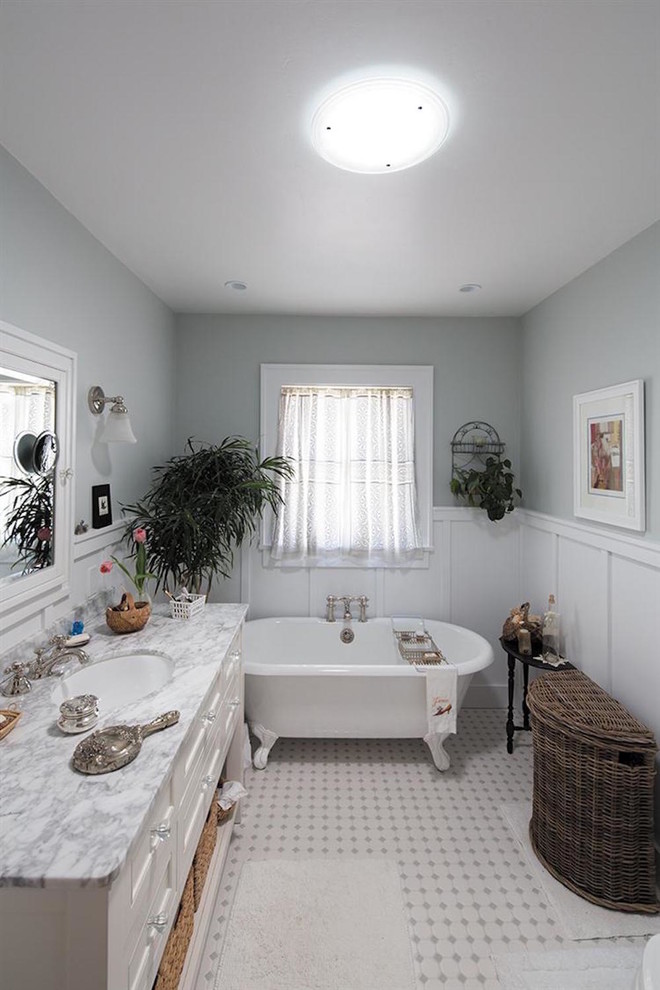 На фото: главная ванная комната среднего размера в викторианском стиле с фасадами островного типа, белыми фасадами, ванной на ножках, серыми стенами, полом из мозаичной плитки, врезной раковиной, мраморной столешницей и разноцветным полом с