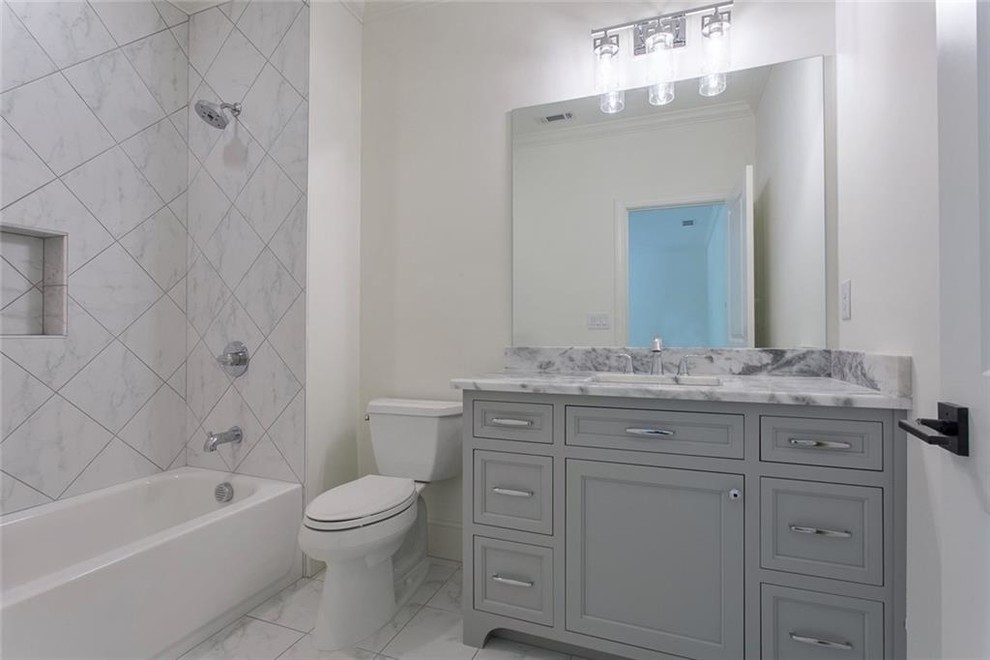 Example of a large transitional 3/4 gray tile and marble tile ceramic tile and white floor bathroom design in Atlanta with recessed-panel cabinets, gray cabinets, a two-piece toilet, white walls, an undermount sink, marble countertops and gray countertops