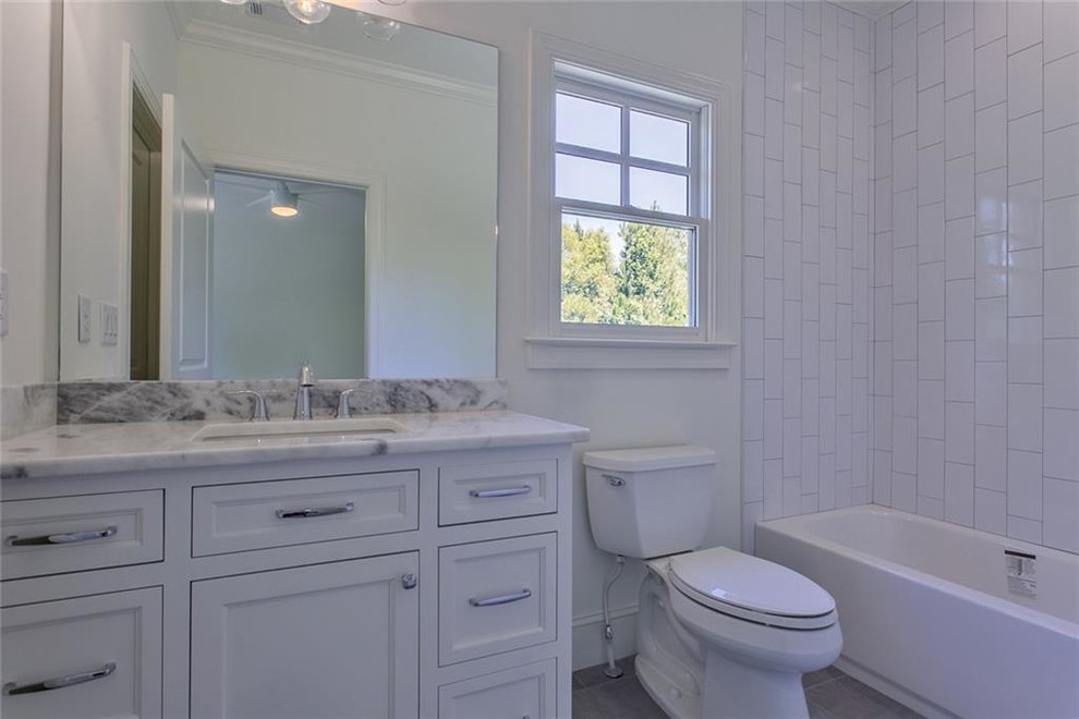 Bathroom - large transitional 3/4 gray tile and marble tile ceramic tile and gray floor bathroom idea in Atlanta with recessed-panel cabinets, gray cabinets, a two-piece toilet, white walls, an undermount sink, marble countertops and gray countertops