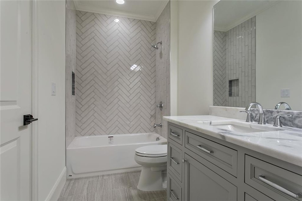 Bathroom - large transitional 3/4 gray tile and marble tile ceramic tile and gray floor bathroom idea in Atlanta with recessed-panel cabinets, gray cabinets, a two-piece toilet, white walls, an undermount sink, marble countertops and gray countertops