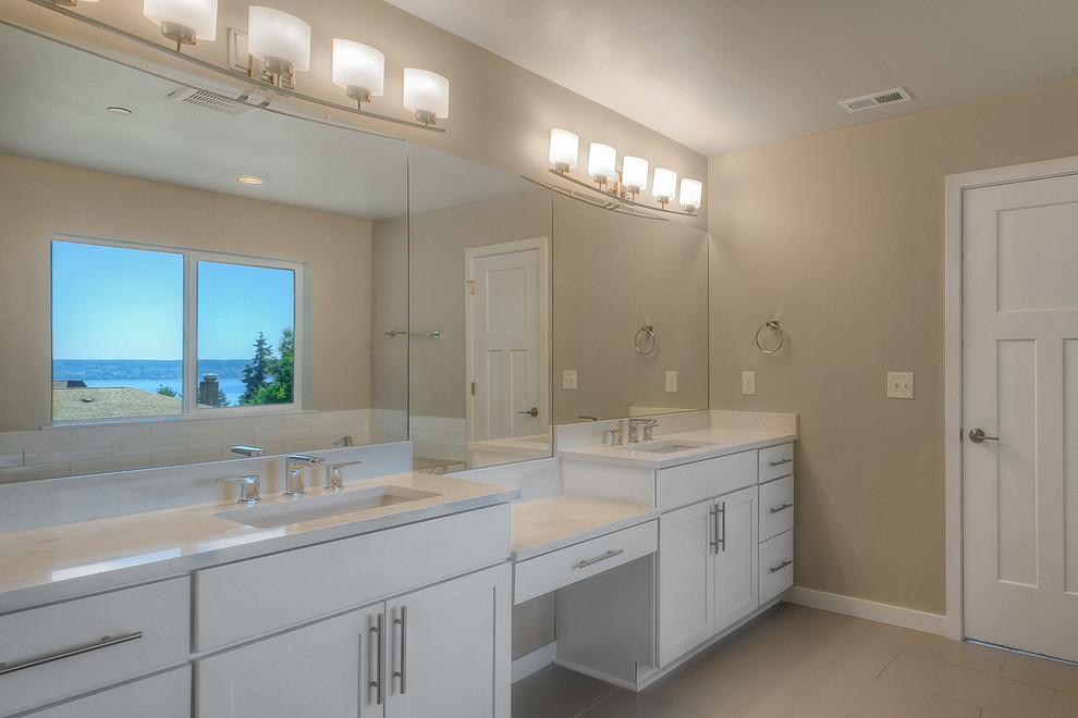 На фото: огромная главная ванная комната в стиле кантри с фасадами в стиле шейкер, белыми фасадами, японской ванной, душем в нише, унитазом-моноблоком, белой плиткой, мраморной плиткой, бежевыми стенами, полом из керамогранита, накладной раковиной, мраморной столешницей, бежевым полом и шторкой для ванной